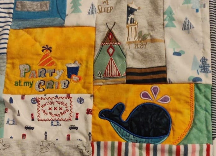 Close up of a memory quilt with the various cut up babygrows